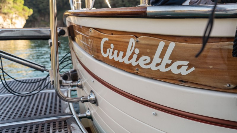 Close-up of a wooden boat named 'Giulietta' docked near water.