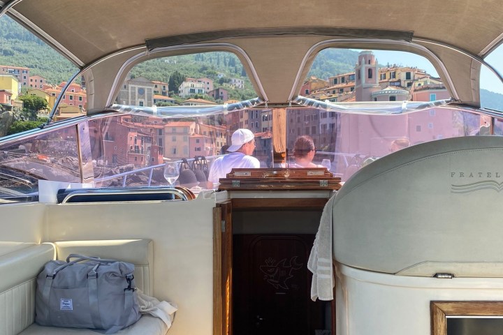 View from inside a boat with basil on table, town visible through window.