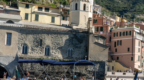 Boat named Princess near seaside buildings and a clock tower in a coastal town.