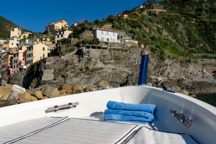 View from a boat of colorful cliffside houses in Cinque Terre, Italy.