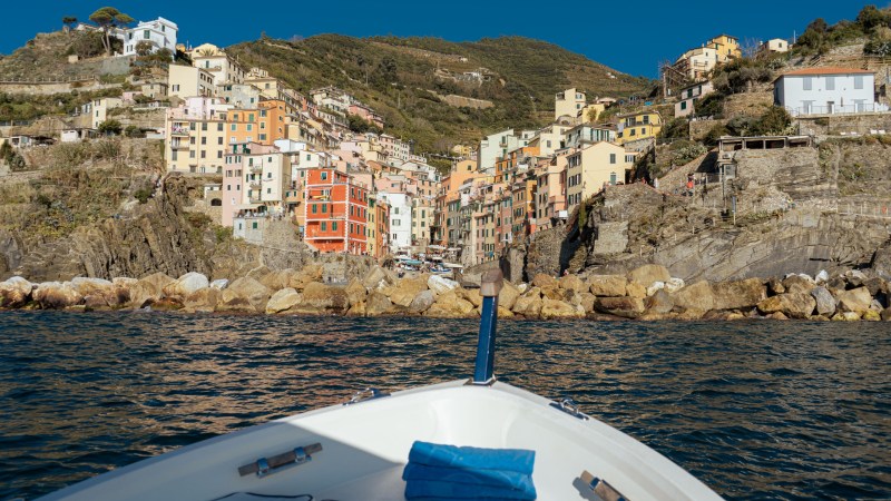 View of colorful hillside buildings from a boat on the water.